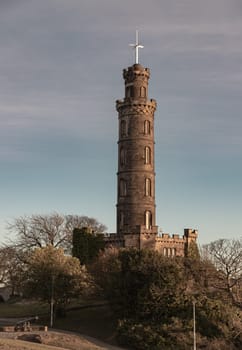 Edinburgh, Scotland - Jan 18, 2024 - Bottom-up view of Nelson's Monument with a bright blue sky in the background. Architecture design of Tower situated on Calton Hill at Edinburgh, Scotland, Space for text, Selective focus.