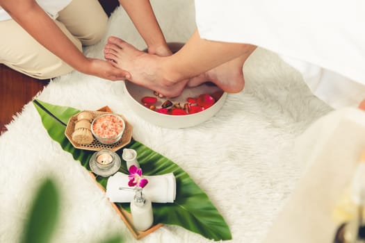 Man indulges in blissful foot massage at luxurious spa salon while masseur give reflexology therapy in gentle day light ambiance resort or hotel foot spa. Quiescent