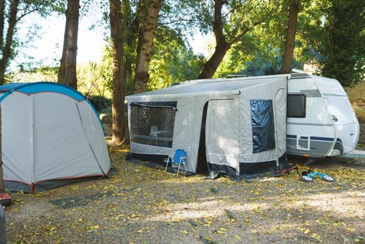 Tents setup for a group camping at the green grass meadow. Multiple blue instant up connectable tents on a campground.