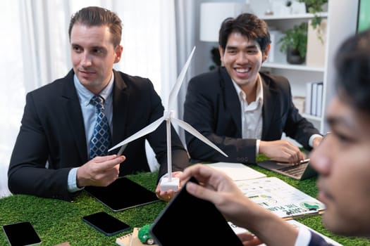 Diverse group of business people planning for alternative energy utilization for greener sustainable Earth by reducing CO2 emission and carbon credit with renewable clean energy technology. Quaint