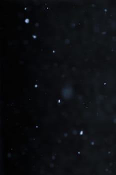 Falling snowflakes on night sky background, isolated for post production and overlay in graphic editor. Bokeh of white snow on a square shape gray background.