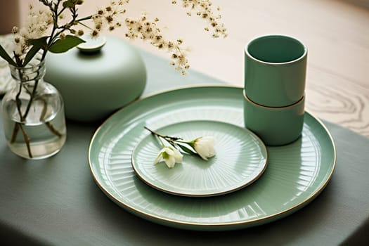 Stylish turquoise tableware with flowers and a vase on the table.