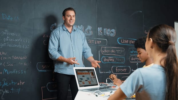 Happy caucasian teacher clap hands to applause student to encourage coding or programing prompt. Diverse student clapping hands to celebrate successful project while attend in STEM class. Edification.