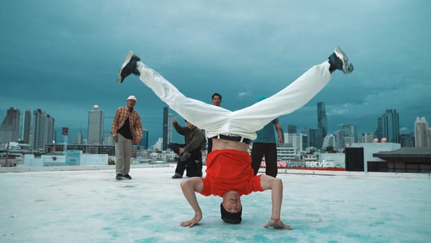 Hispanic hipster dancing surrounded by multicultural friend at city view with blue sky. Group of street dancer performing at rooftop. Active, fun, happy atmosphere. Outdoor sport 2024. Endeavor.