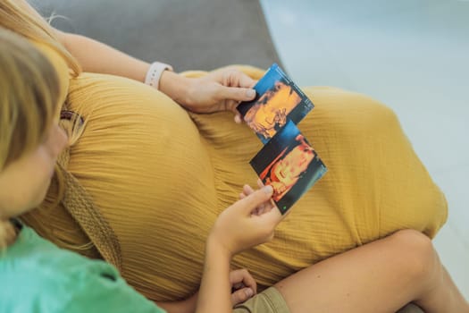 Expectant mother tenderly shares the joy of her unborn baby with her son, showing him heartwarming ultrasound photos of his soon-to-arrive little brother.