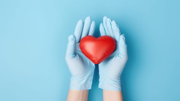 Hands in medical blue gloves holding red heart on blue background. St Valentine's Day vibe
