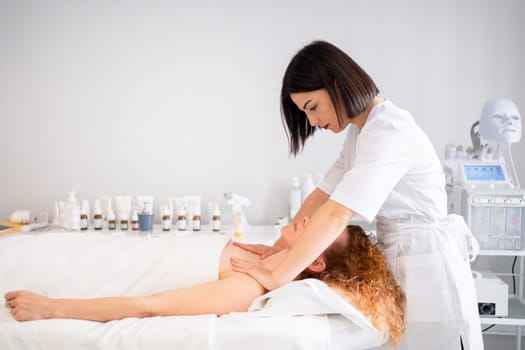 Side view of masseuse massaging woman's head, shoulders, and neck in beauty center. Beauty Treatments. Body care, skin care, wellness, and wellbeing concepts.