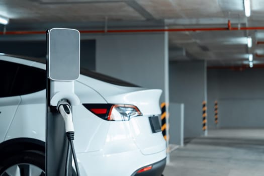 EV electric car recharge at shopping center parking lot charging in downtown city showing urban sustainability lifestyle by green clean rechargeable energy of electric vehicle innards