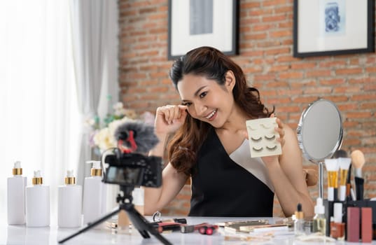 Asian Woman influencer shoot live streaming vlog video review makeup uttermost social media or blog. Happy young girl with cosmetics studio lighting for marketing recording session broadcasting online