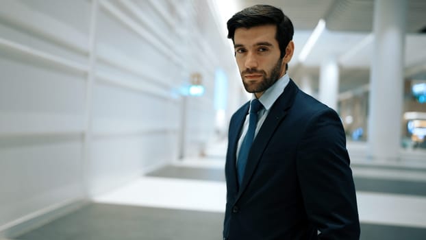 Portrait of smart business man looking at camera while standing with blurred background. Closeup of successful man staring at camera while wearing business suit. Business meeting or seminar. Exultant.