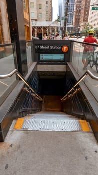 Entrance and stairs down to Wall Street subway station in New York, USA. New York City Subway is one of the world's oldest public transit systems. New York, USA - July 15, 2023.