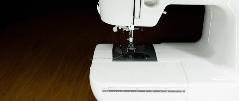 white sewing machine on a wooden table. High quality photo