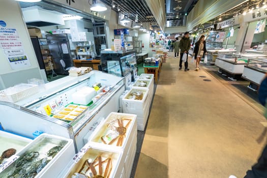 Tokyio, Japan. January 2024. People among stalls selling fresh fish at the Tsukiji Outer Market in the city centre