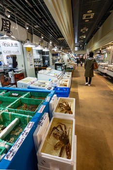 Tokyio, Japan. January 2024. People among stalls selling fresh fish at the Tsukiji Outer Market in the city centre