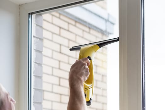Cleaning windows with electric vacuum cleaner. Spring house cleaning- image