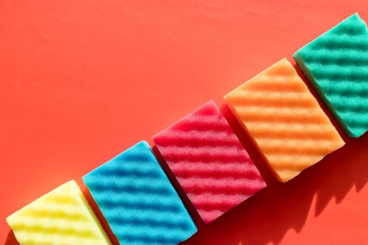 Brightly colored sponges on white background with copy space.