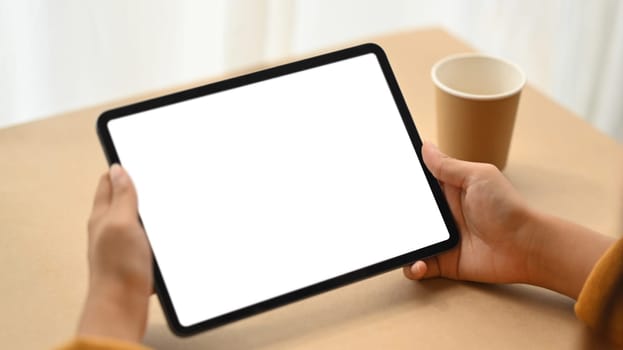 Close up woman hands holding digital tablet with empty screen for advertising text.