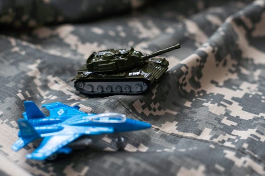 Toy tank with camouflage color . Military vehicles toy. Simple cheap toys for children , warfare, warzone vehicles, kids playing war, abstract concept nobody. High quality photo
