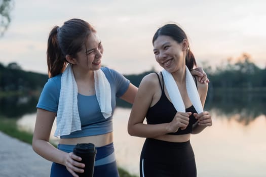 Two happy women going for sunrise running. Women in track suits running at park.