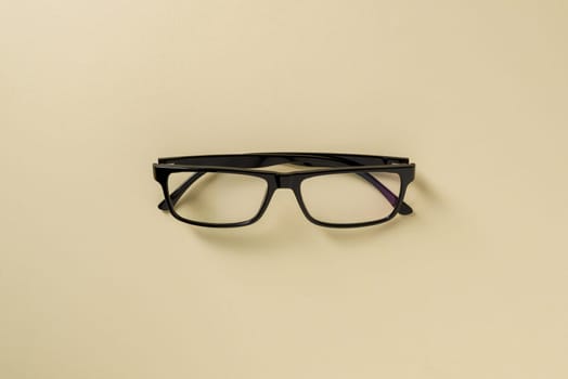 Prescription glasses with black frames on a yellow background
