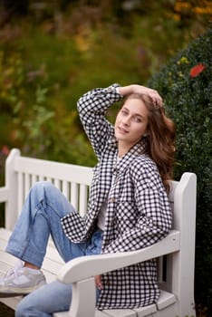 Charming Autumn Casual: Beautiful Girl on Park Bench.