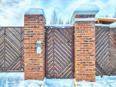 New gate, entrance to a private territory on a winter day and snow. Metallic texture and background. Fence