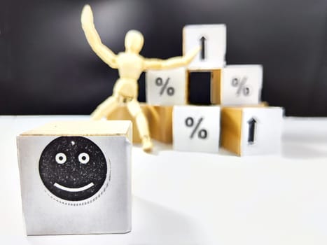 Wooden cubes in a column and row with white signs with a smiley sign, an arrow, a percentage. The concept of positivism. Positive thinking leads to the achievement of results and profits