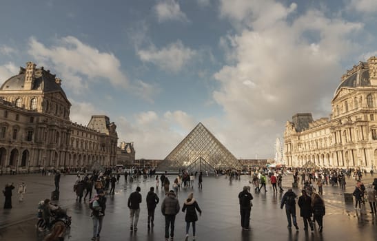 France, Paris - Jan 03, 2024 - Tourist visit at the courtyard of the Louvre Museum outside during day time by after raining. is one of the world's largest museums in Paris, Space for text, Selective focus.