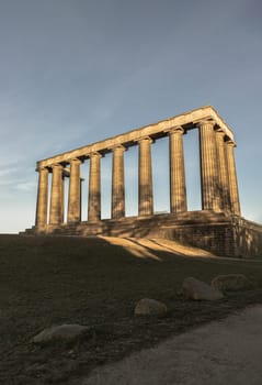 Edinburgh, Scotland - Jan 18, 2024 - A view of the National Monument of Scotland with a bright blue sky in the background situated on Calton Hill at Edinburgh city. Scotland, Space for text, Selective focus.
