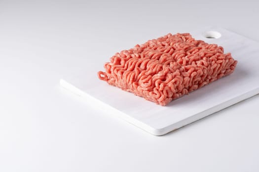 Raw minced meat on a white table.