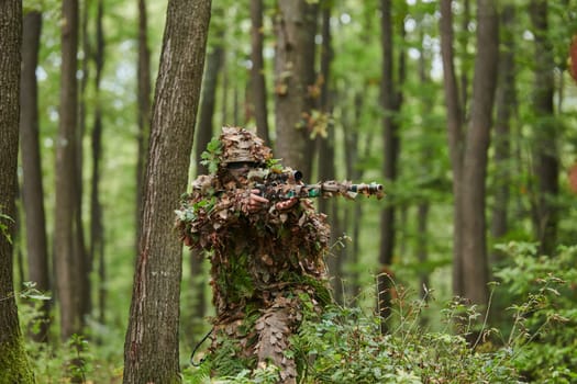 A highly skilled elite sniper, camouflaged in the dense forest, stealthily maneuvers through dangerous woodland terrain on a covert and precise mission.