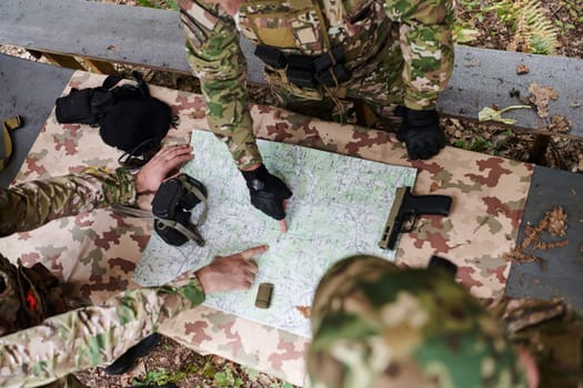 A highly trained military unit strategizes and organizes a tactical mission while studying a military map during a briefing session.