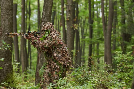 A highly skilled elite sniper, camouflaged in the dense forest, stealthily maneuvers through dangerous woodland terrain on a covert and precise mission.