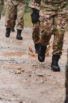 Close up photo, the resilient legs of elite soldiers, clad in camouflage boots, stride purposefully along a hazardous forest path as they embark on a high-stakes military mission.
