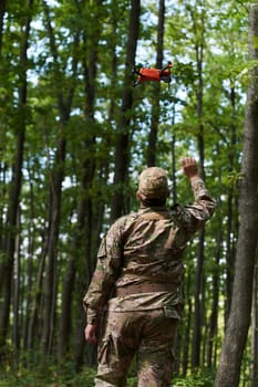 Elite military unit, equipped with state-of-the-art technology including a drone, strategically navigates and surveys dangerous wooded terrain, showcasing their precision, cooperation, and specialized training for high-risk operations.