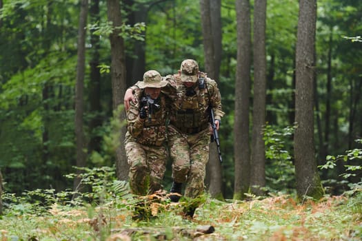 Elite soldier displays unwavering camaraderie and compassion as he aids his injured comrade, skillfully extracting him from the forest with a stretcher, showcasing the profound bond and selflessness within their military brotherhood.