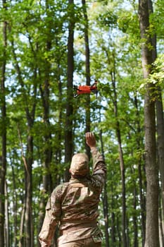 Elite military unit, equipped with state-of-the-art technology including a drone, strategically navigates and surveys dangerous wooded terrain, showcasing their precision, cooperation, and specialized training for high-risk operations.