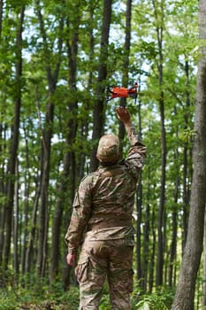 Elite military unit, equipped with state-of-the-art technology including a drone, strategically navigates and surveys dangerous wooded terrain, showcasing their precision, cooperation, and specialized training for high-risk operations.