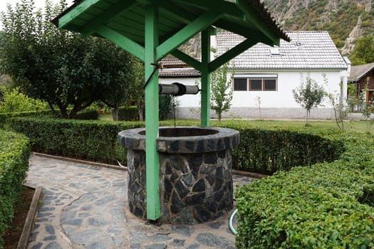 a stone well under a wooden canopy in the house of the clairvoyant seer Vanga in the village of Rupite, Bulgaria.