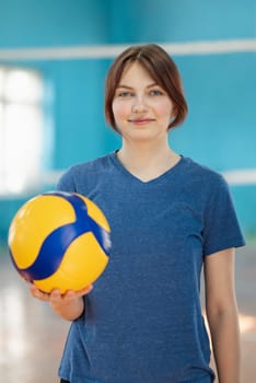 Portrait of a sporty female in volleyball court with ball