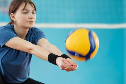 Young female mastering volleyball skills on volleyball court
