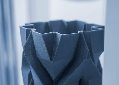 Art object vase printed on a 3D printer. Models created by a 3D printer from blue molten plastic. Concept 3d printing. Additive progressive technologies. New modern technology for creating objects