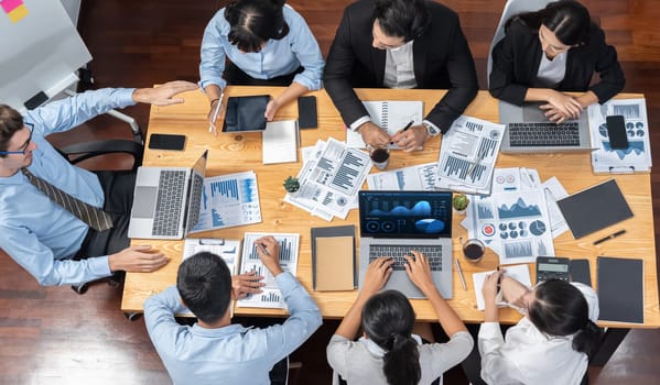 Panorama top view diverse group of business analyst team analyzing financial data report paper on meeting table. Chart and graph dashboard by business intelligence analysis. Meticulous