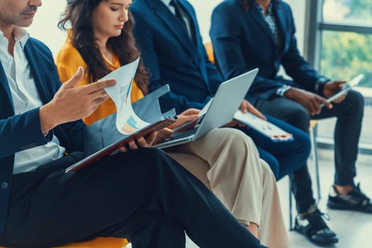 Diversity candidates waiting for job interview. Intellectual. Low section crop of interviewees sitting on a chair while preparing their document and themselves for presentation. Intellectual.