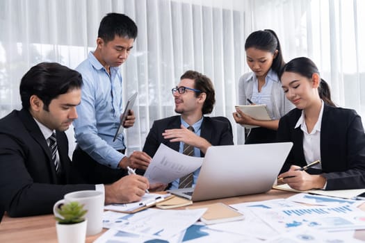 Diverse group of business analyst team analyzing financial data report paper on office table. Chart and graph dashboard by business intelligence analysis for strategic marketing planning Meticulous