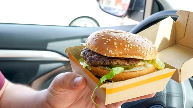 Man is eating Big Mac at McDonald's restaurant. Man ordered Burger in McDonald's restaurant for take out. Ottawa Canada 08.15.2023.