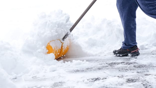 Man shoveling snow off of his driveway after a winter storm in Canada. Man with snow shovel cleans sidewalks in winter. Winter time