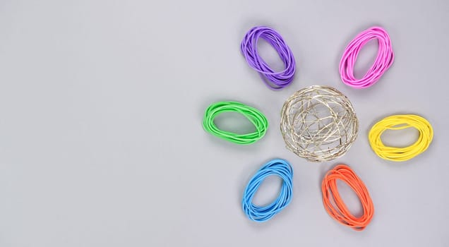 Multicolored flower made of elastic. Top view of colorful rubber bands isolated on white. Rainbow elastic rubber bands on white. Rainbow flower shape