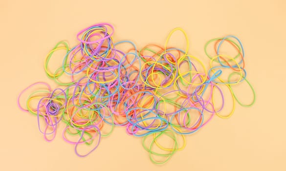 Colored rubber bands for money on bright yellow paper background. Abstract background. Stationery accessories