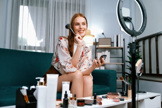 Woman influencer shoot live streaming vlog video review makeup utmost social media or blog. Happy young girl with cosmetics studio lighting for marketing recording session broadcasting online.